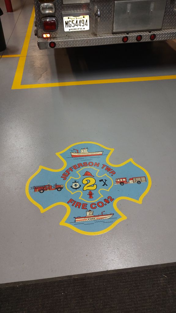 Fire station grey epoxy floor with lines and custom logo closeup — Jefferson Twp, NJ